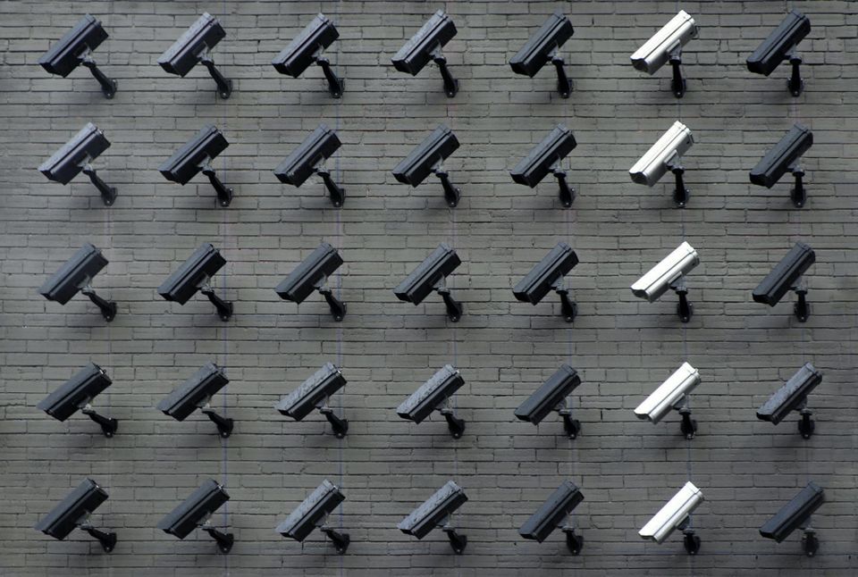 Image: Rows of security cameras on a brick wall