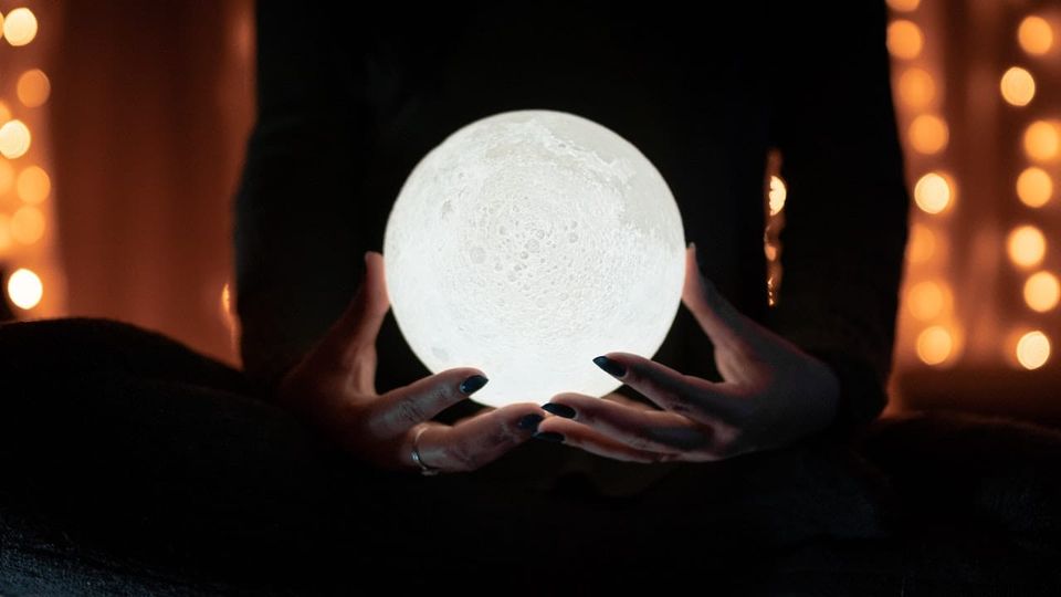 Image: Silhoutted human holding crystal ball
