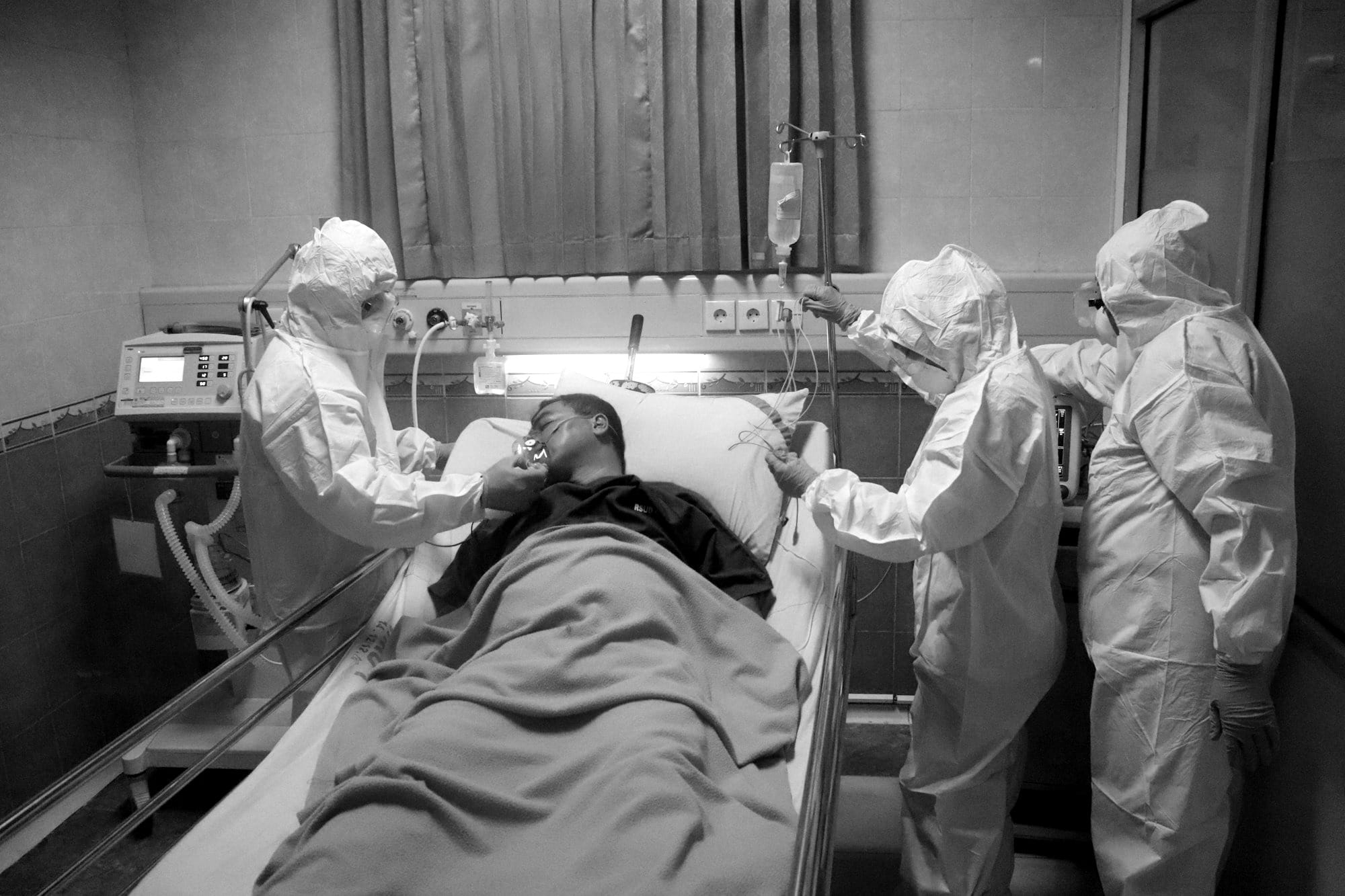 man in white scrub suit lying on hospital bed
