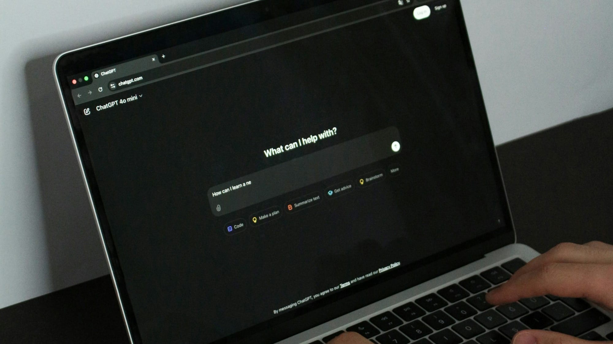 A person typing on a laptop on a table