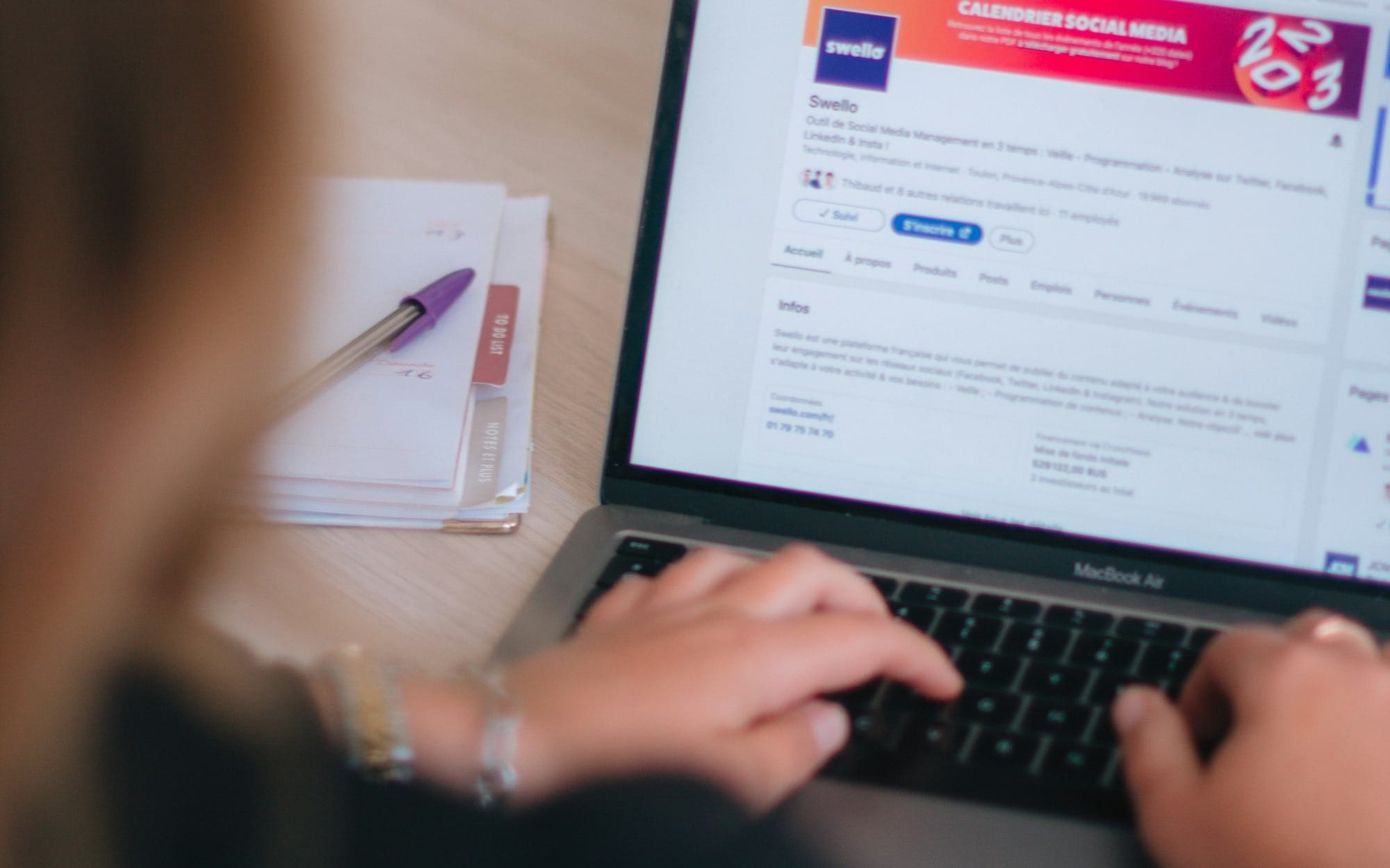 a woman sitting at a table using a laptop computer