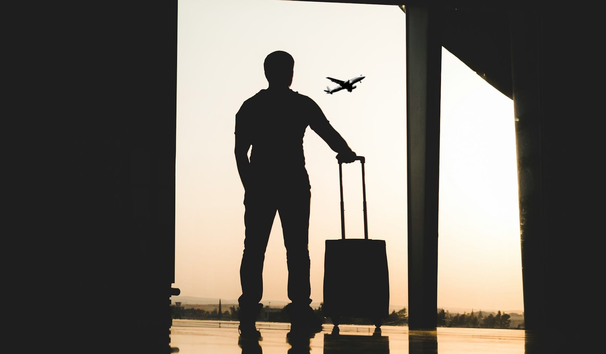 silhouette of man holding luggage inside airport