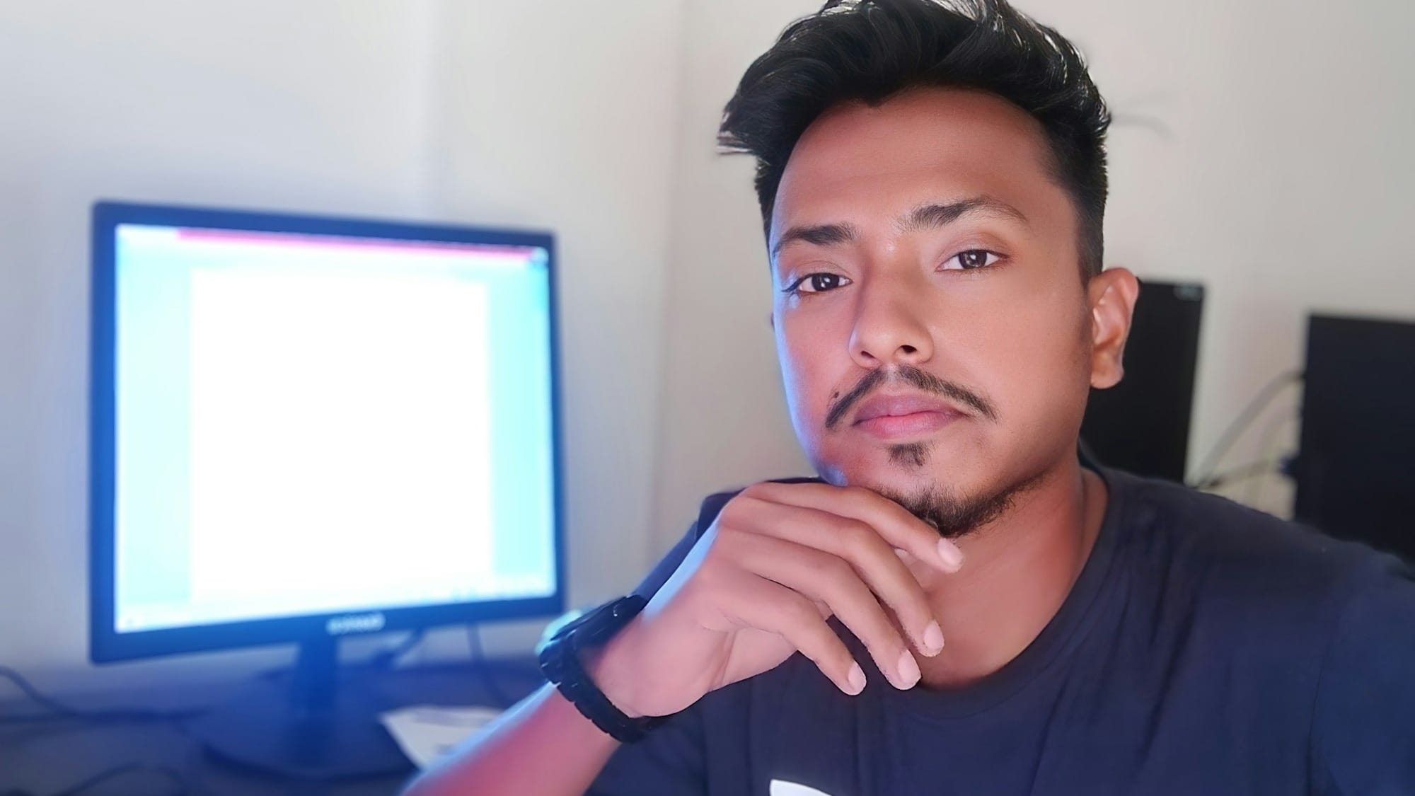 A man sitting in front of a computer monitor