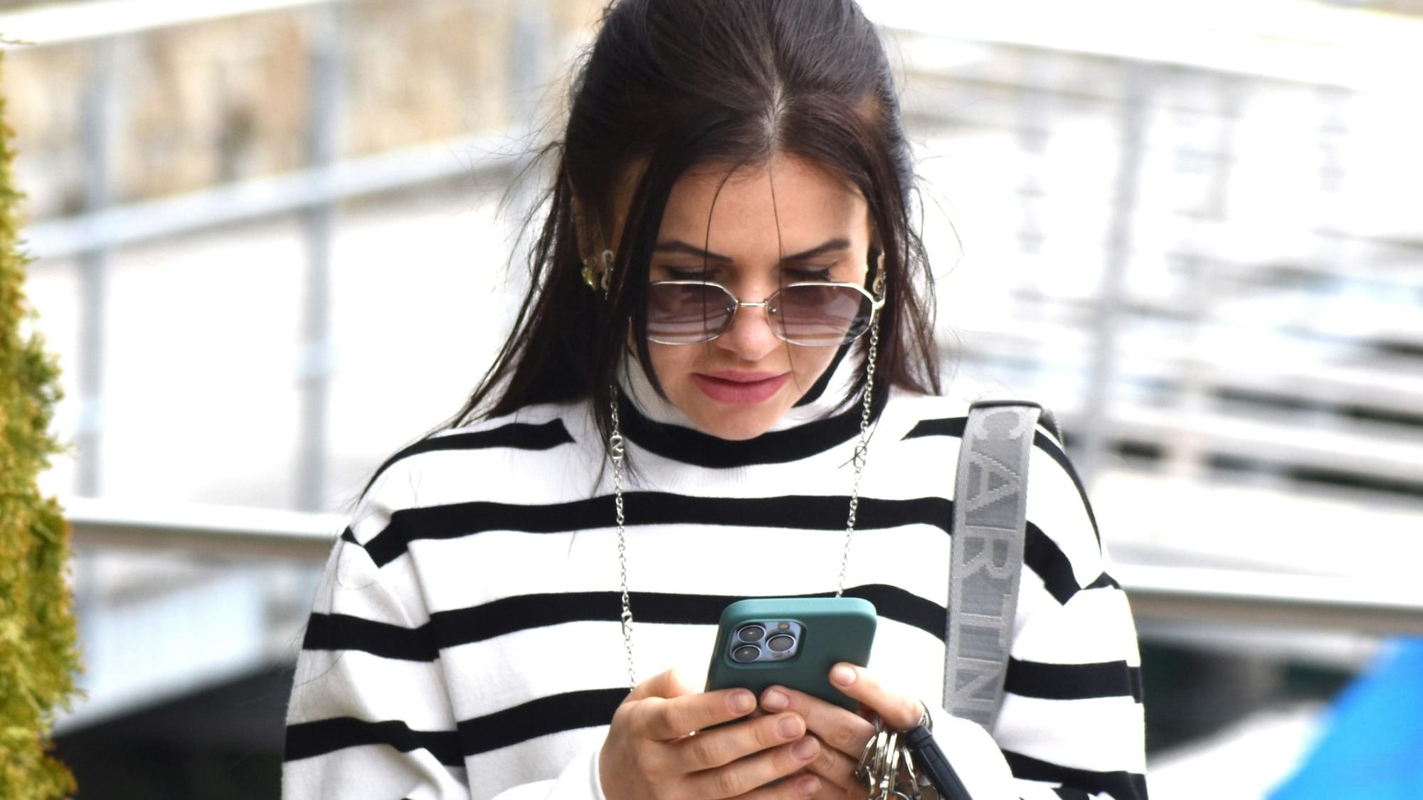 Woman in striped sweater looking at smartphone