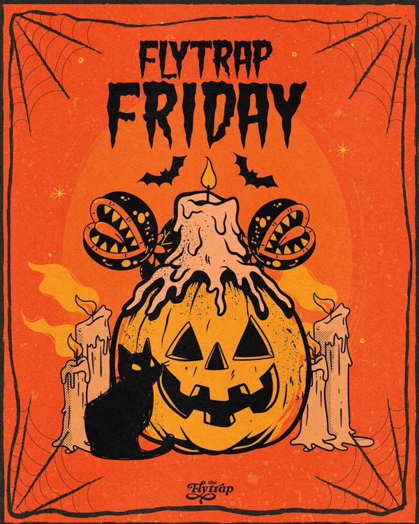 A jack-o-lantern surrounded by candles and Venus flytraps with a black cat.