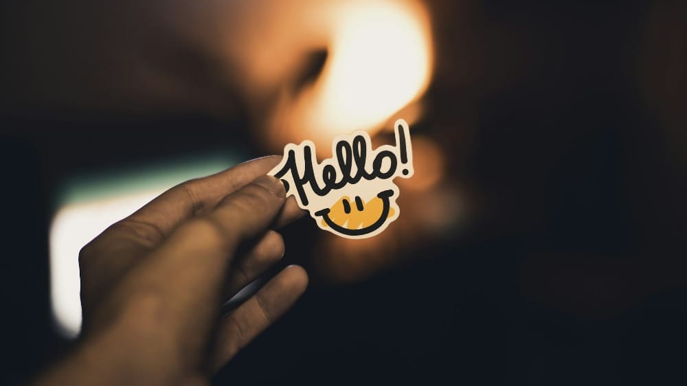 person holding Hello! sticker