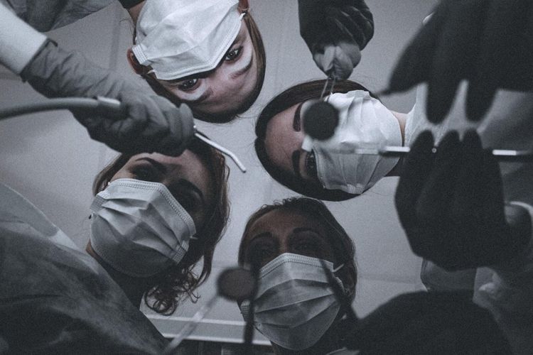 women wearing face masks holding dental tools