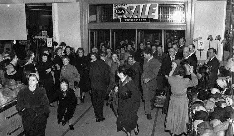 Large group of people rushing into a store for Black Friday