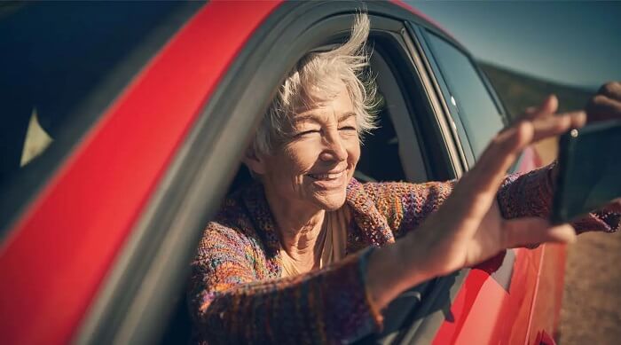 IMG_Elderly_lady_taking_photos_from_a_red_car_XL