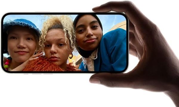 A hand holding a iPhone showing a group selfie