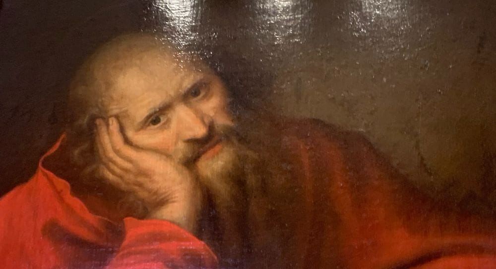 St. Jerome in an oil painting, resting his head on his hand and looking bored beyond measure.