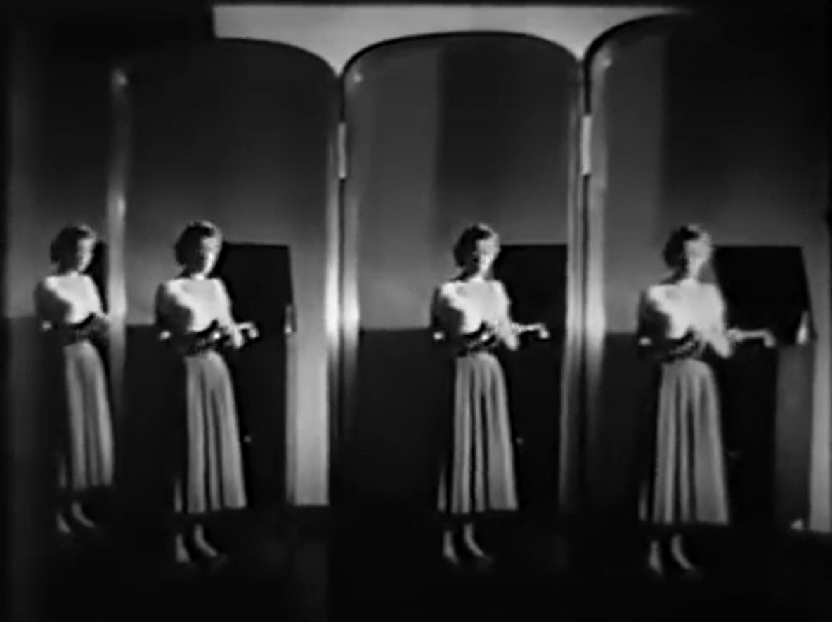 An image from the film Jennifer showing four reflections of Ida Lupino in a multi-faceted mirror. She's out of focus, so while you can tell she's a woman in a light-colored sweater and a long skirt, you can't get much more detail.
