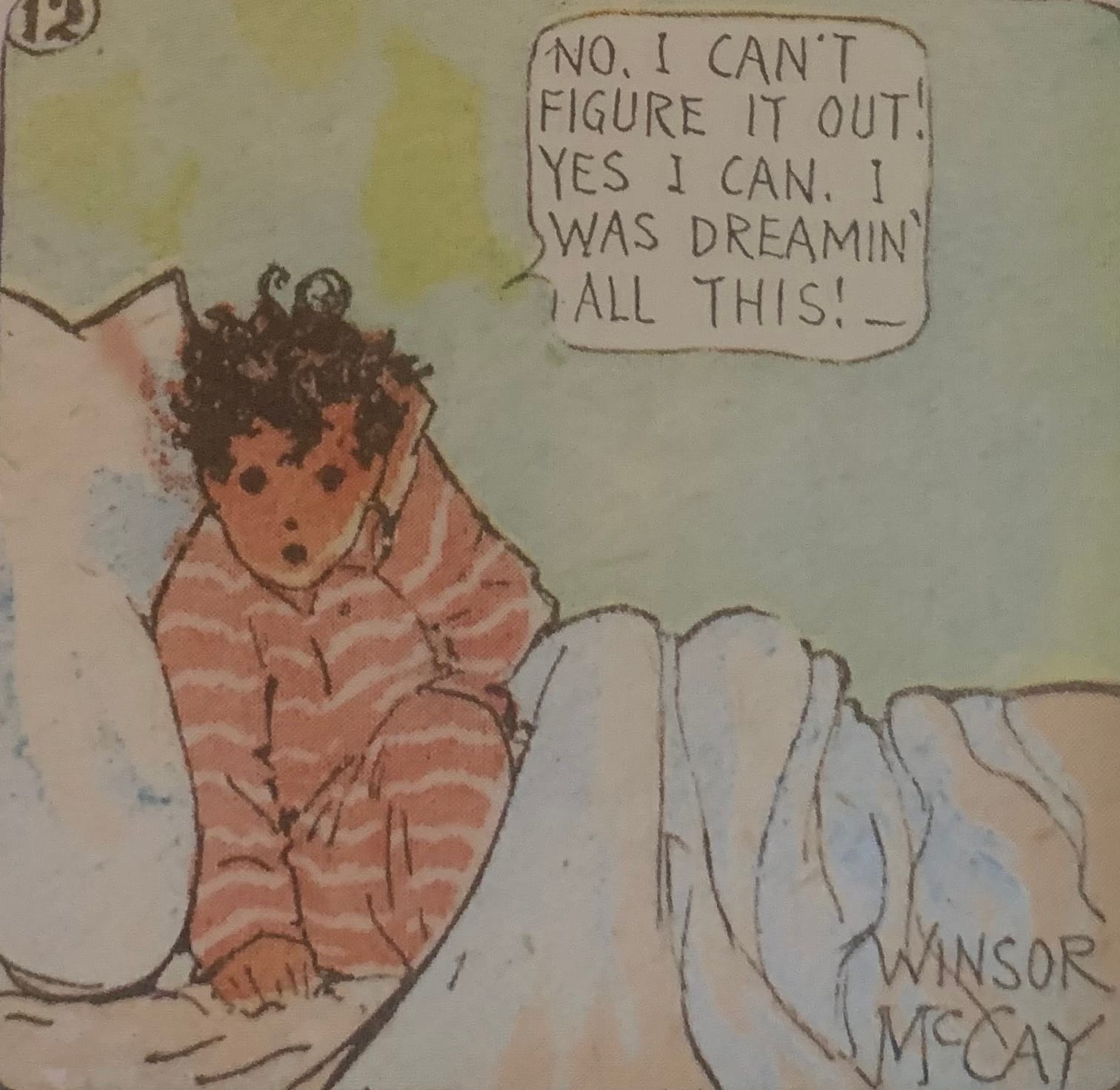 A cartoon showing a young boy with dark, tousled hair wearing striped pajamas. He's sitting up in bed with a hand to his head as if in modest confusion. He is saying, "No, I can't figure it out. Yes I can. I was dreamin' all this!" In the bottom right corner is Winsor McCay's signature.