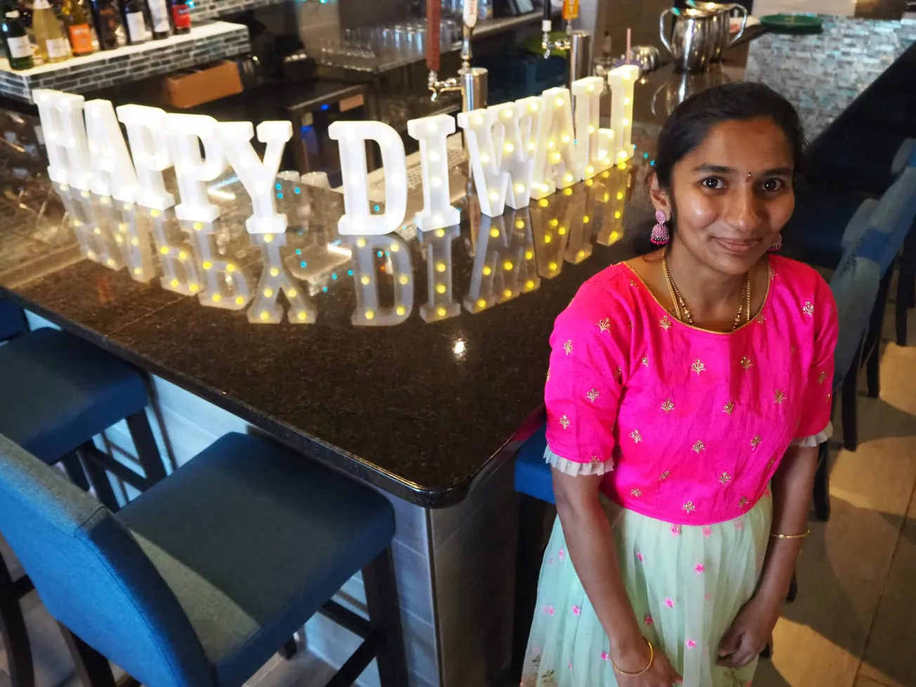 Saisowjanya Chaganti, who works at India K'Raja restaurant in Henrico County posed next to a lit up Happy Diwali sign during a special buffet.