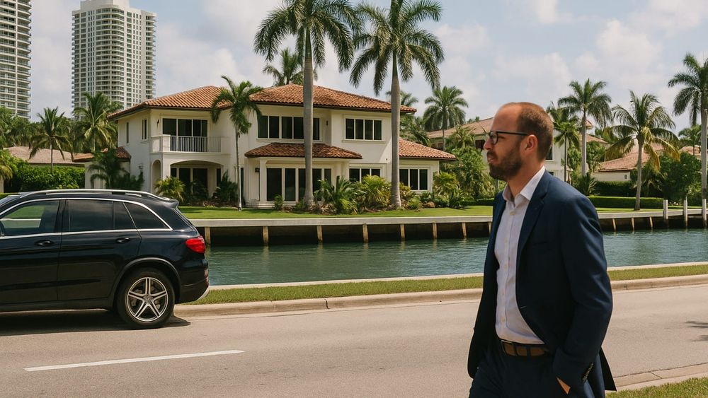 A man in a suit walks past a South Florida luxury waterfront mansion, highlighting prime high-end real estate.