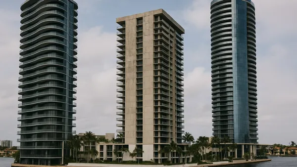 Three luxury condominium towers rise along a South Florida waterway.