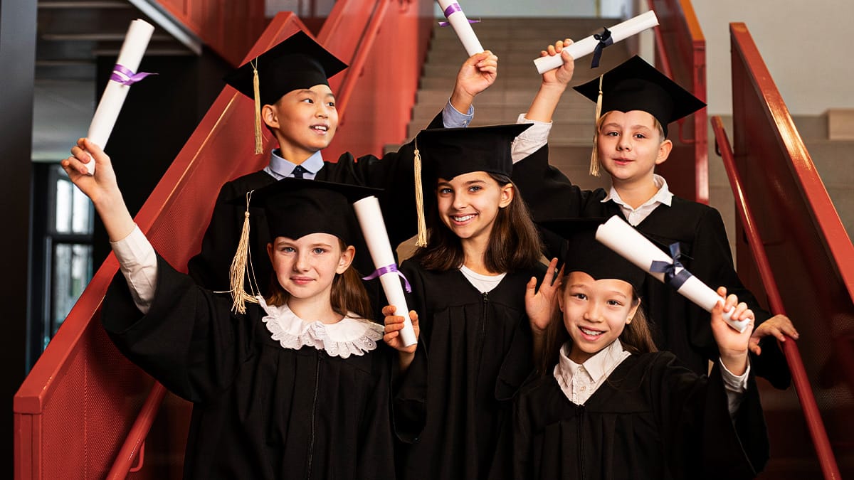 Young graduates posing proudly on a staircase after a ceremony