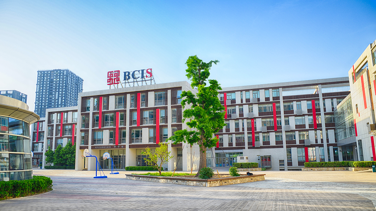 Beijing City International School featuring contemporary architecture with red accents and outdoor recreational facilities.