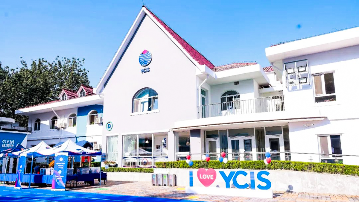 YCIS international school campus with white buildings, blue accents, and 'I Love YCIS' sign.