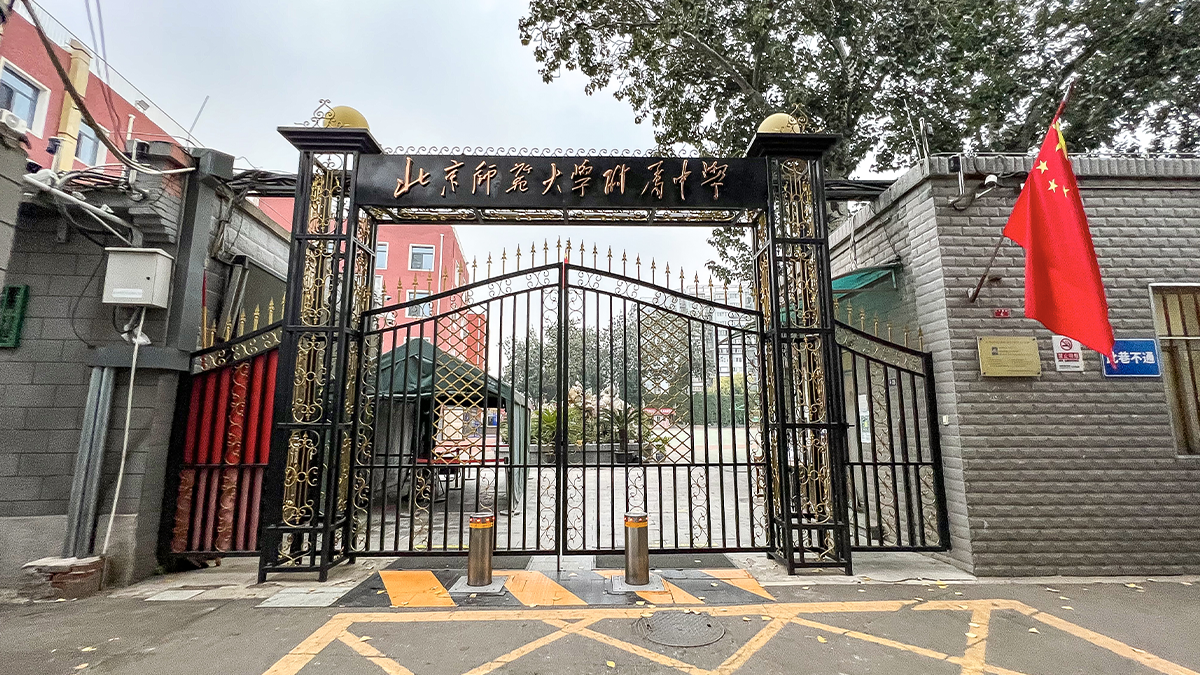 The high school affiliated with Beijing Normal University entrance gate with Chinese signage displayed.