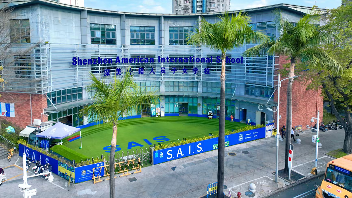 Shenzhen American International School campus featuring modern glass architecture and tropical palm landscaping.