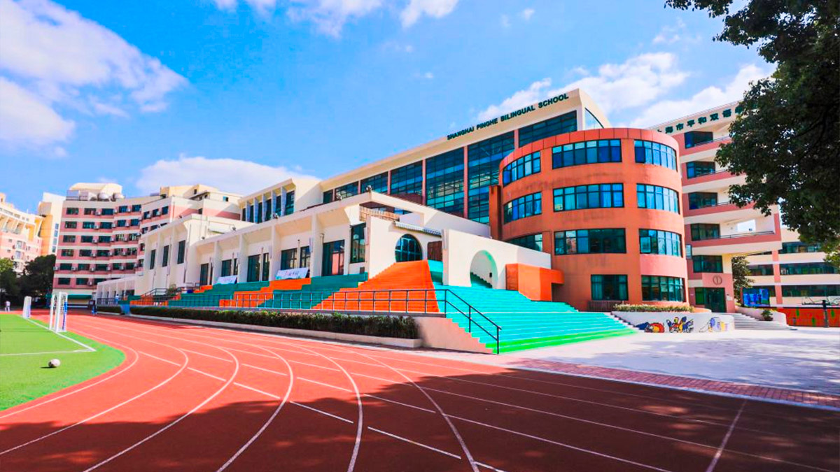 Shanghai Pinghe School campus featuring colorful modern architecture with running track and athletic facilities.