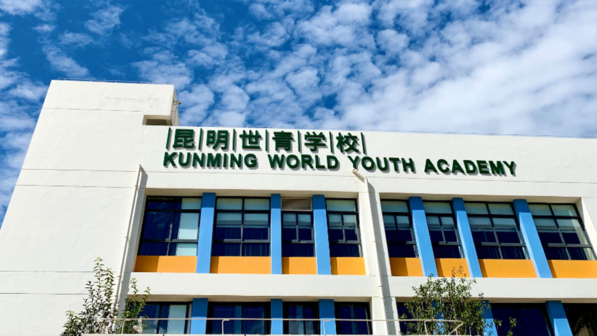 Kunming World Youth Academy with large windows and bilingual identification signage.