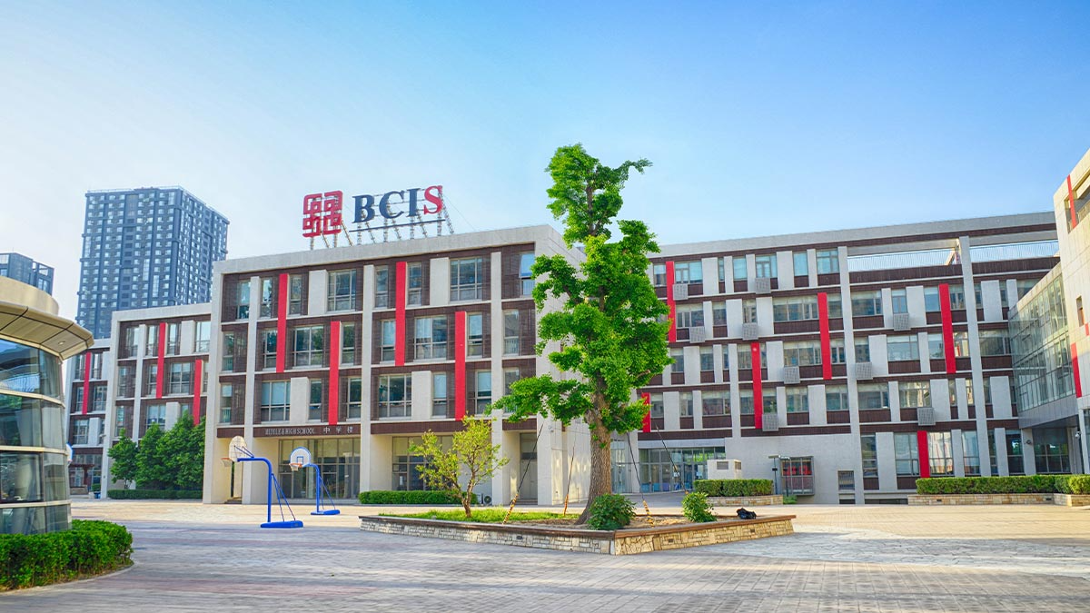 Beijing City International School campus featuring modern multi-story buildings with distinctive red accent stripes.
