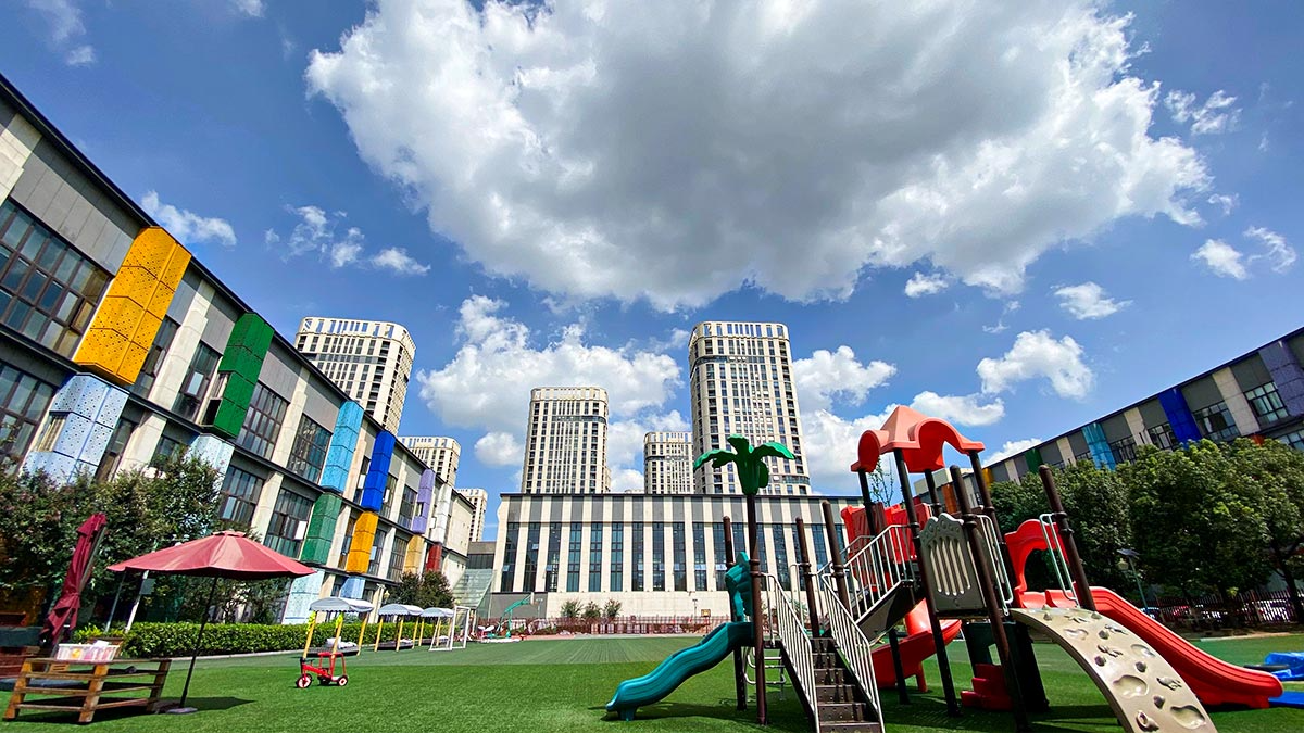 EtonHouse International School Nanjing campus featuring colorful playground equipment and modern urban buildings.