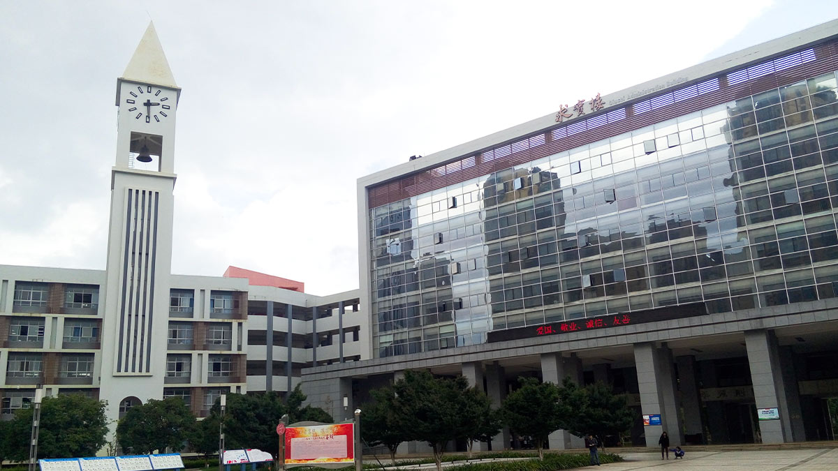 International Department of Kunming Number Ten Middle School featuring tall clock tower and modern glass building.