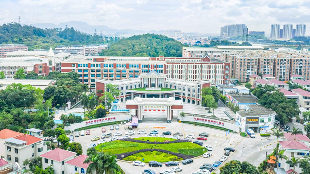 Guangdong Country Garden School aerial view showing expansive campus with classical architecture and mountain backdrop.