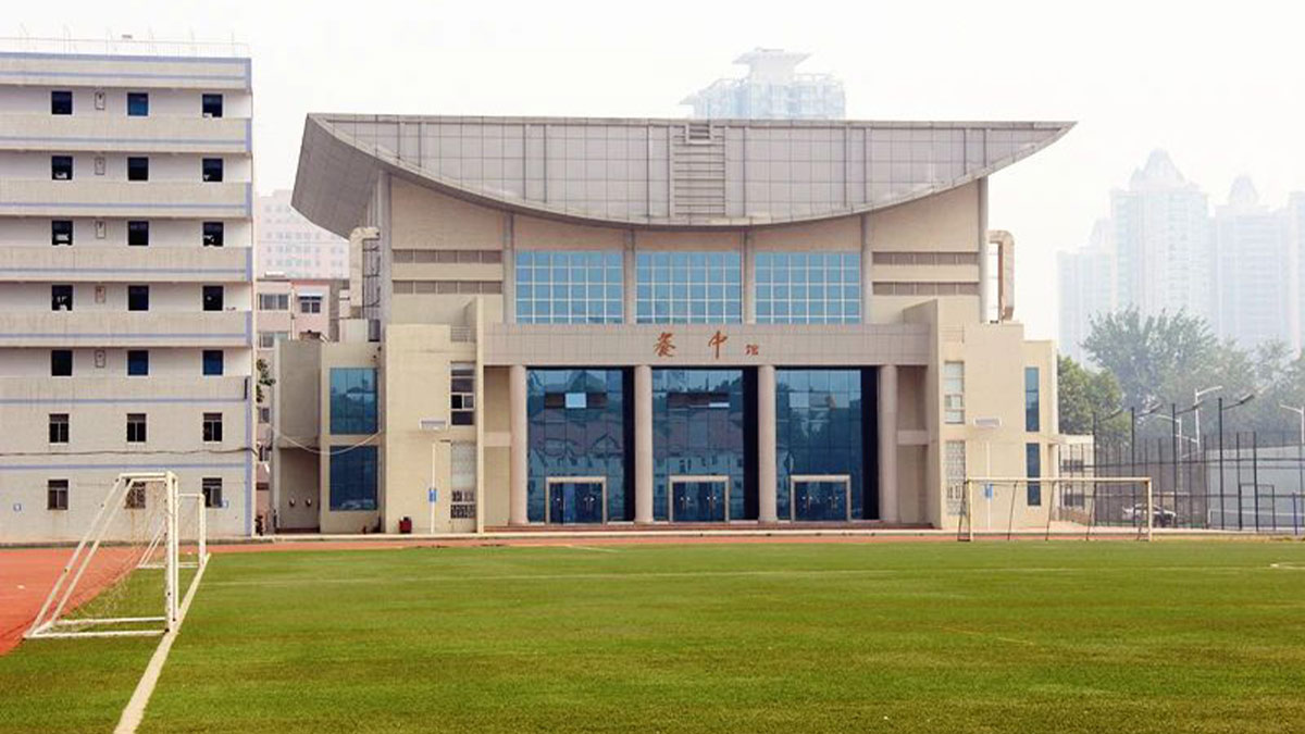 Zhengzhou No. 9 High School International Department featuring modern curved architecture and soccer field.