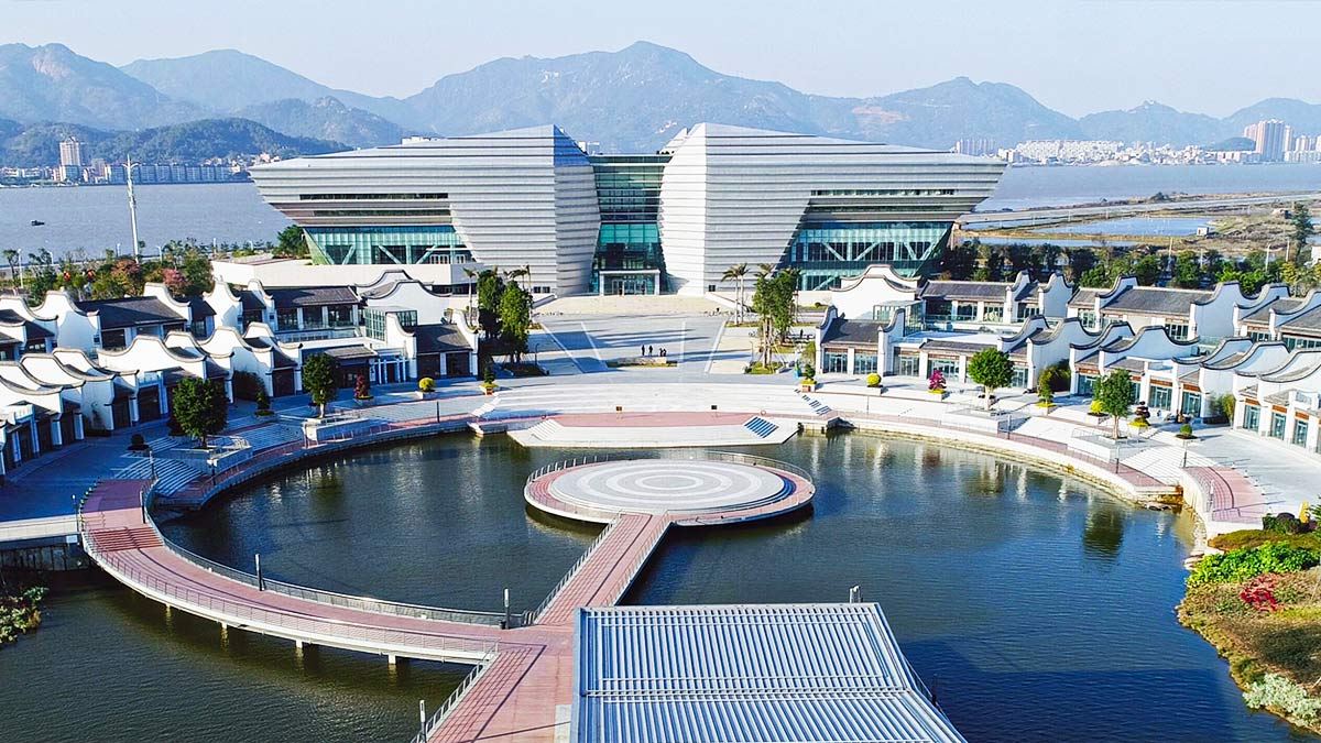 Fuzhou Sunshine International Exchange Center featuring modern architecture with a waterfront location and mountain backdrop.