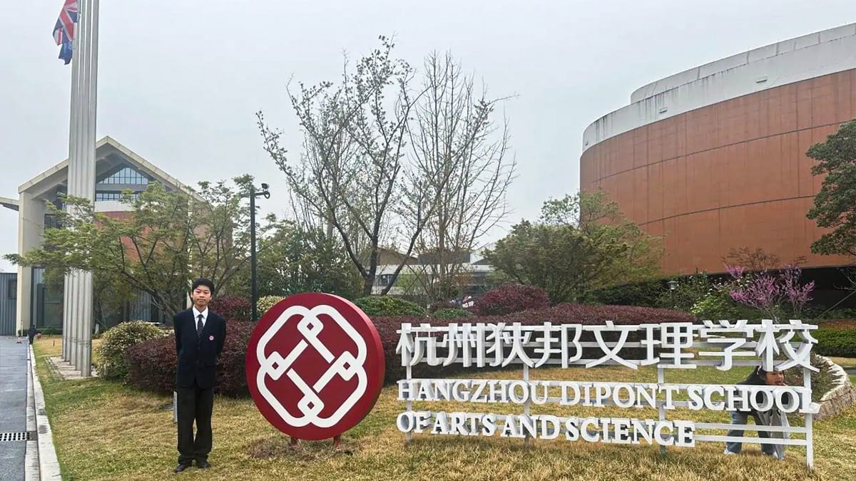 Hangzhou Dipont School of Arts and Science campus entrance sign with student in uniform