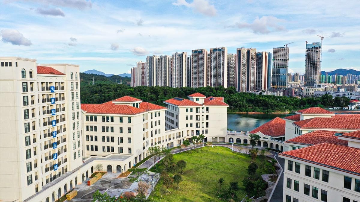 Shenzhen Foreign Languages GBA Academy campus with red-roofed buildings and green courtyard