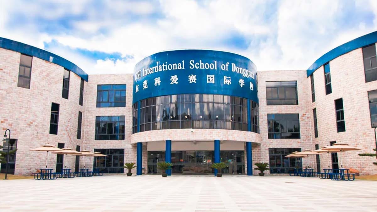 QSI International School of Dongguan modern campus building with blue curved entrance.