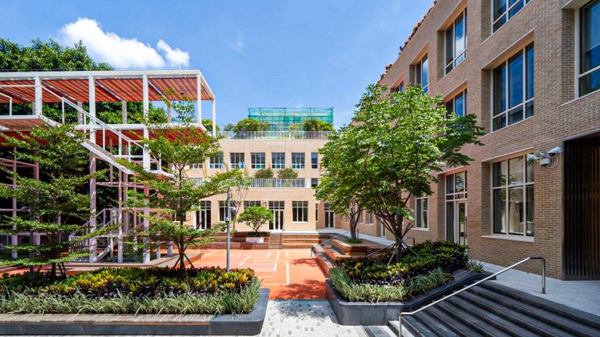Avenues: The World School Shenzhen campus courtyard with landscaped gardens and brick buildings