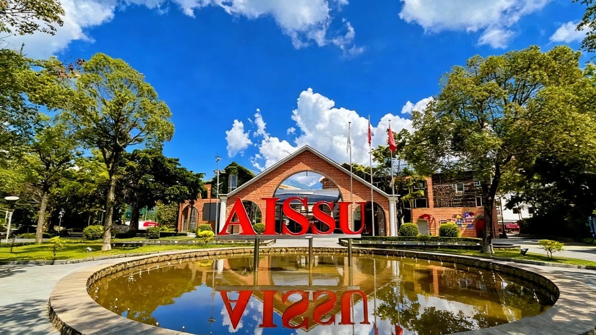 Bromsgrove School Mission Hills entrance with red AISSU sign and reflective pond