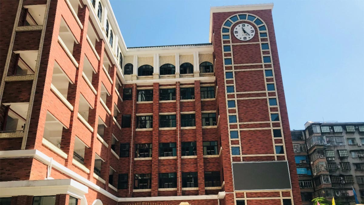 Guangzhou Overseas Chinese Foreign Language School red brick building exterior with clock tower and multi-story campus architecture.
