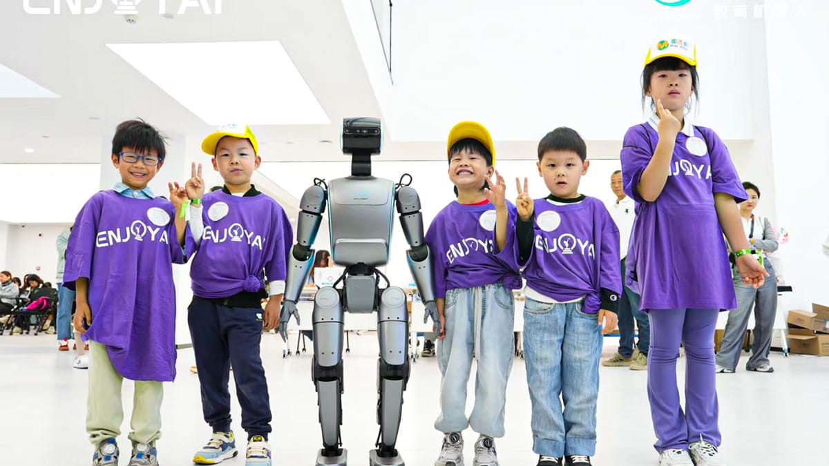 STEM Study Tours participants pose with humanoid robot during technology workshop