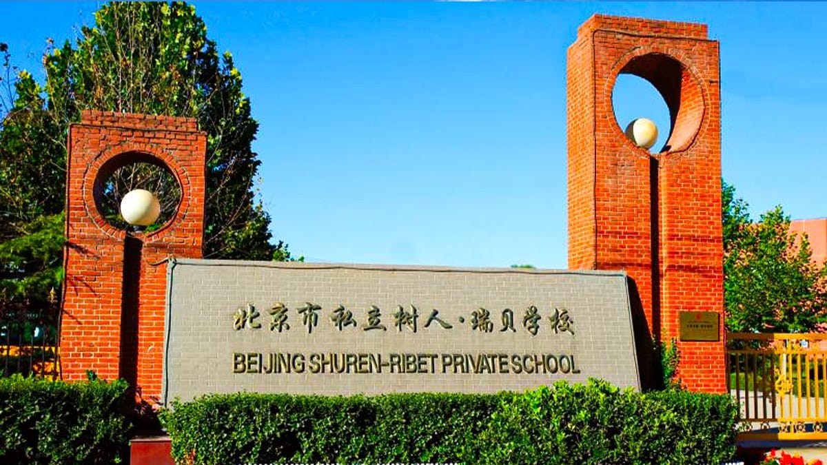Beijing Shuren-Ribet Private School entrance sign with brick pillars and circular light fixtures