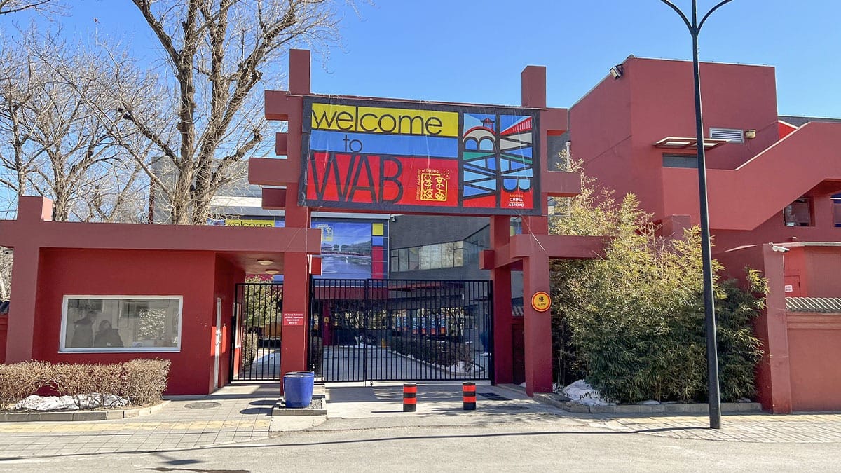 Western Academy of Beijing entrance gate with welcome sign and red architecture