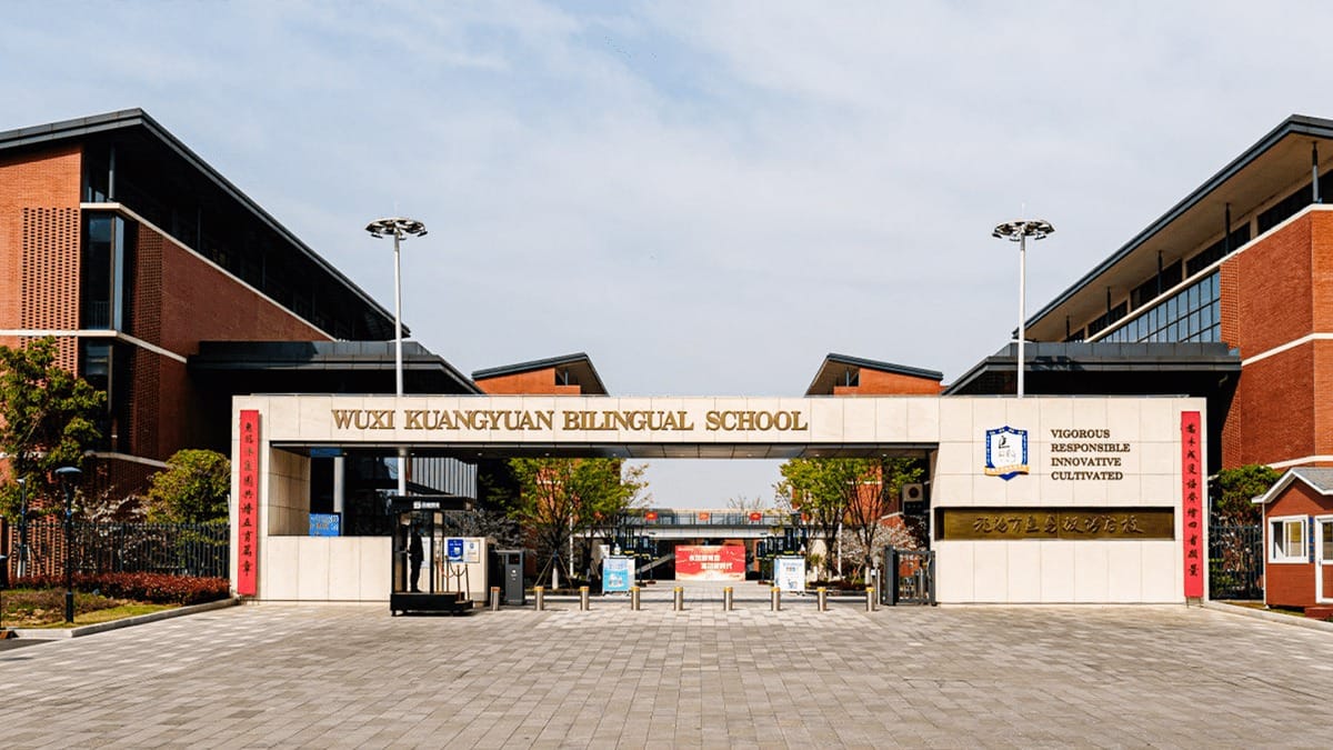 Wuxi Kuangyuan Bilingual School entrance with modern brick buildings and security gate
