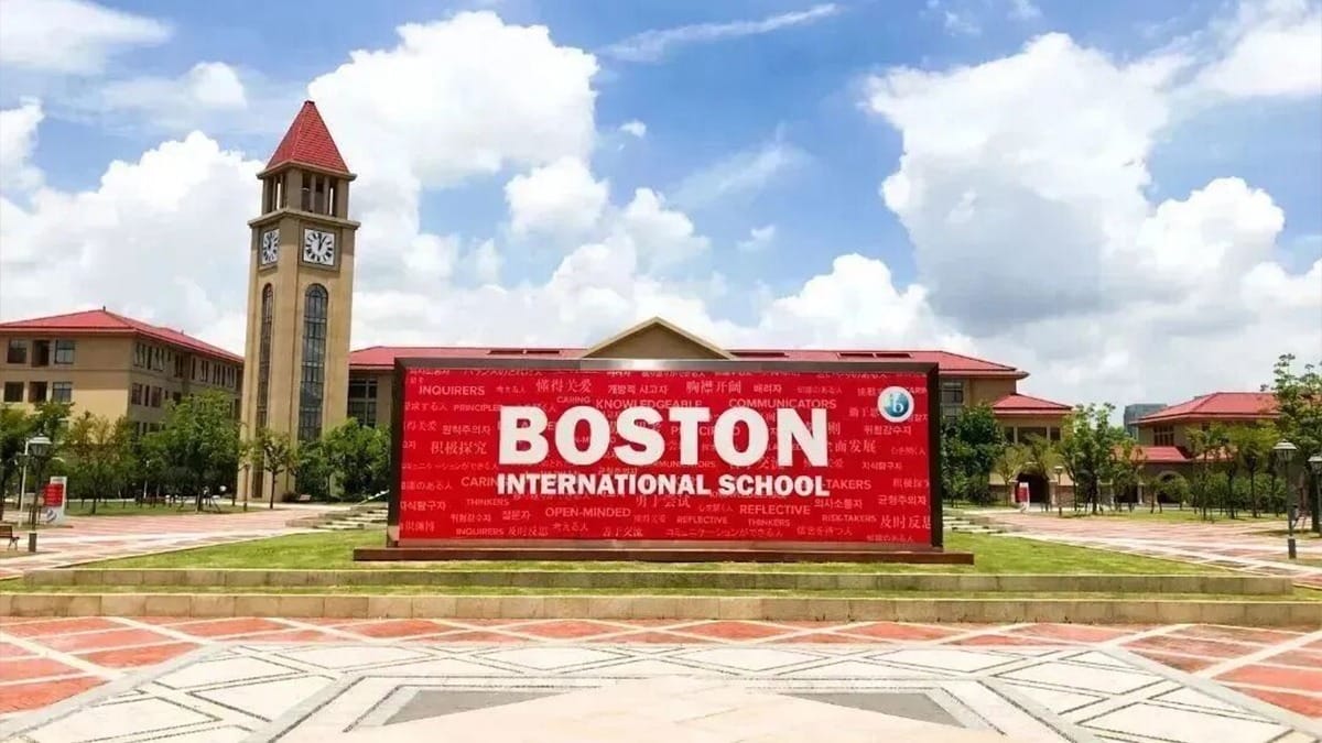 Wuxi Boston International School campus featuring clock tower and red entrance sign
