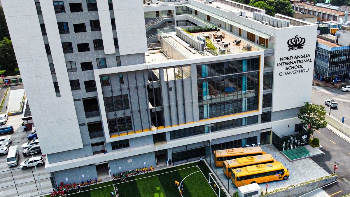 Nord Anglia School Guangzhou modern campus with rooftop terrace and yellow school buses
