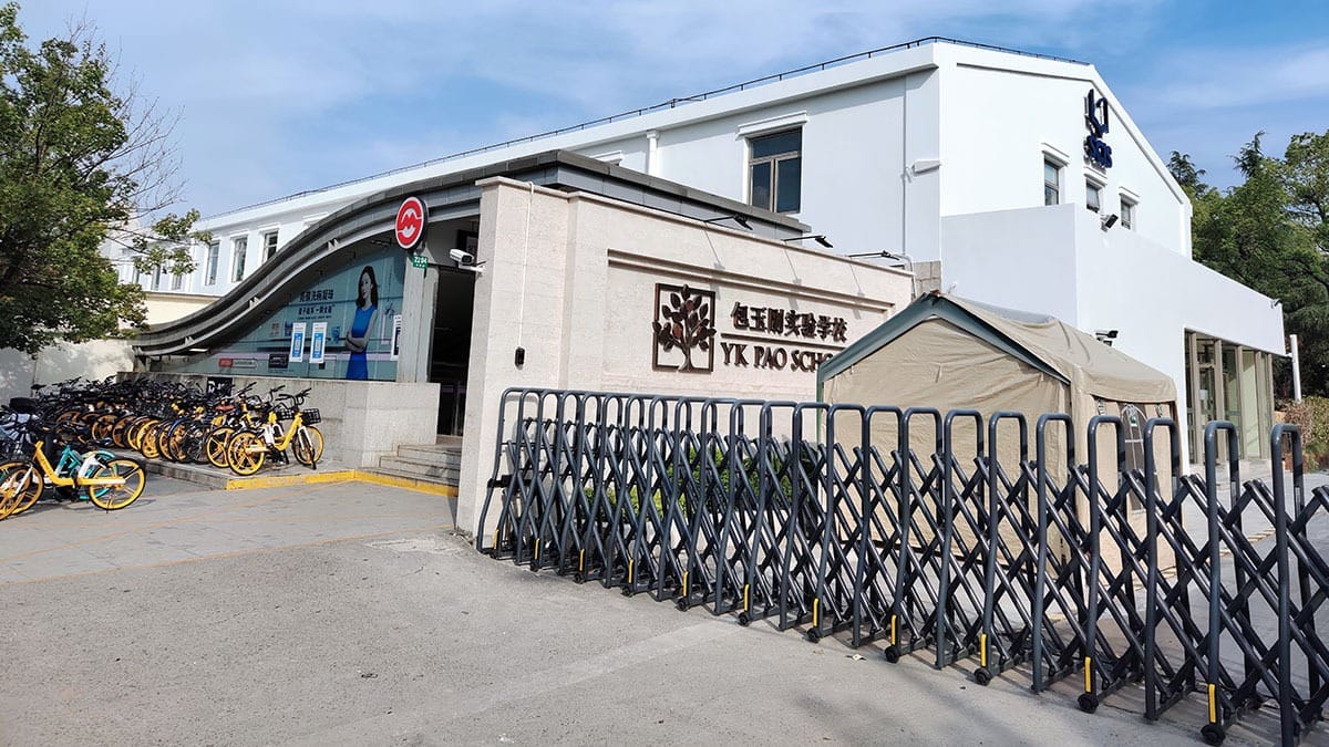 YK Pao School entrance with modern white buildings and security gate