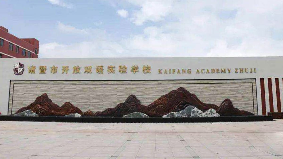 Kaifang Academy Zhuji entrance wall with mountain mural and bilingual school signage
