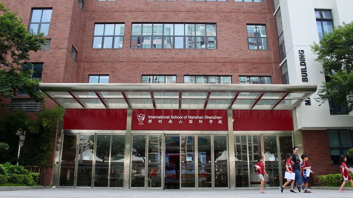 International School of Nanshan Shenzhen main entrance with red signage and students