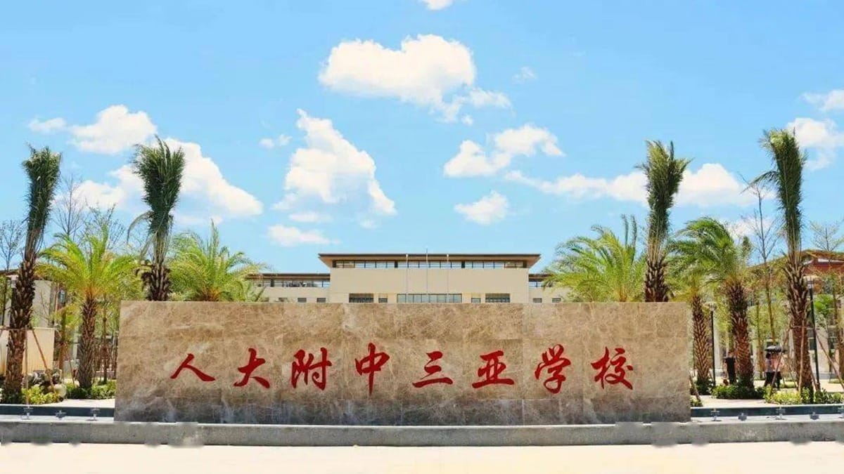 RDFZ Sanya School entrance stone monument with palm trees and modern campus building