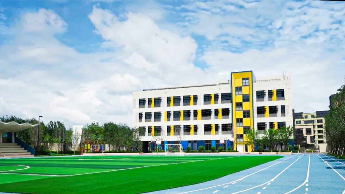 HuZ Deutsche Schule Shenyang campus with white and yellow buildings and sports field